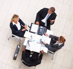 Business people sitting at a table for a meeting in English.
